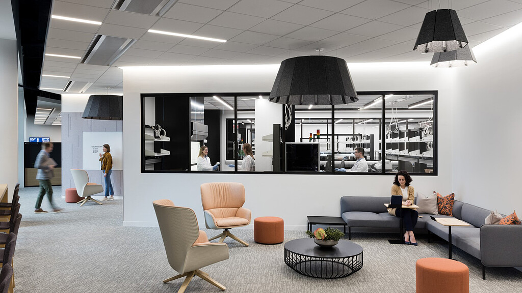 A person sitting on a couch in a room with a large screen.